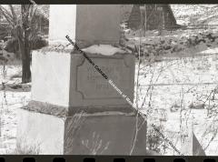 B&W photo in winter of gravestone of J.P. Harlow.