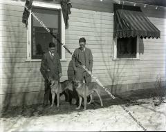 Negative of a man his son and two dogs