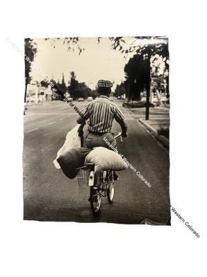 Photo of unidentified individual riding bicycle