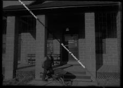 Man with wheelbarrow in front of the Uintah office 
