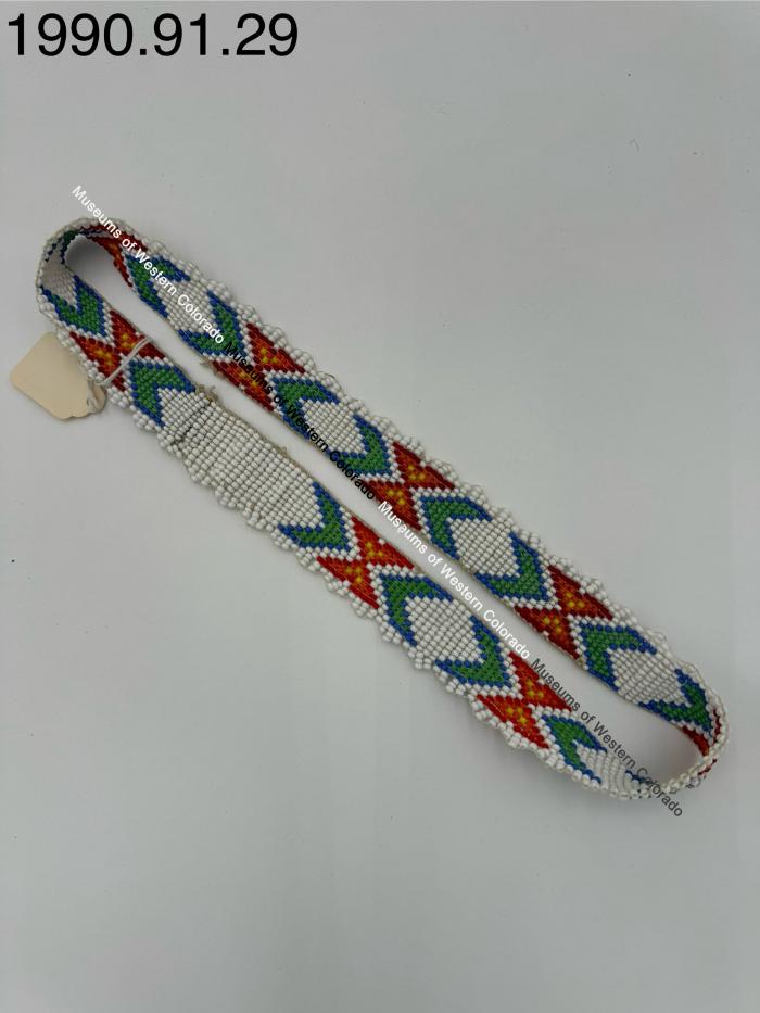 White beaded headband with 'x' and arrow design